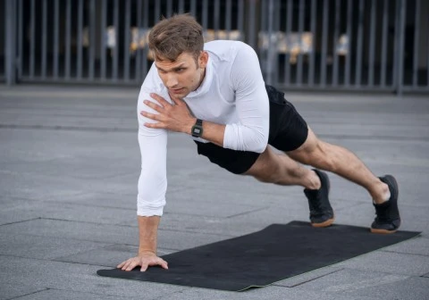 A man is performing Plank with Shoulder Taps