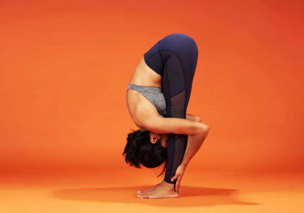 Girl is doing Standing Forward Bend  effective stretches for lower back